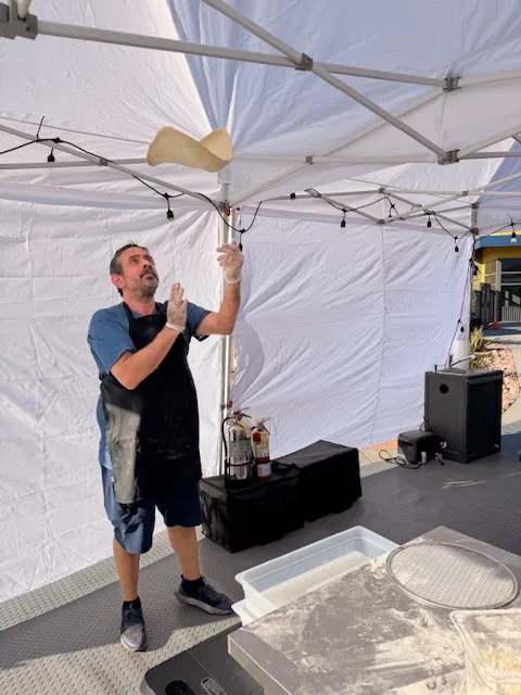 The founder hand-tossing pizza dough inside the Ferruccio's tent