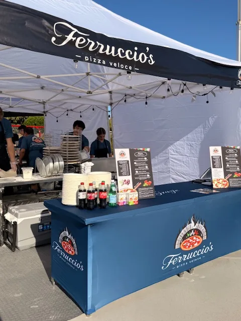 Ferruccio's branded tent and serving tables at a daytime event