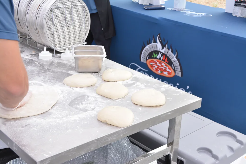 Dough balls resting on a floured prep table beside the Ferruccio's counter