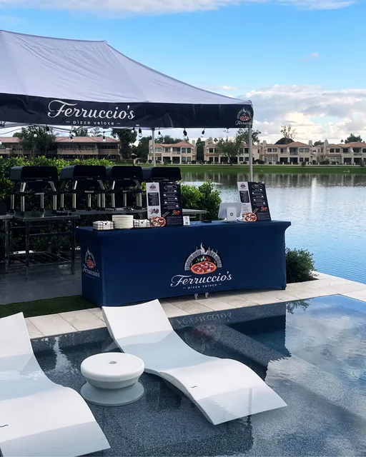 Ferruccio's tent and ovens set up beside a backyard pool and lake